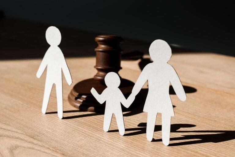 paper people near wooden gavel on table, divorce concept