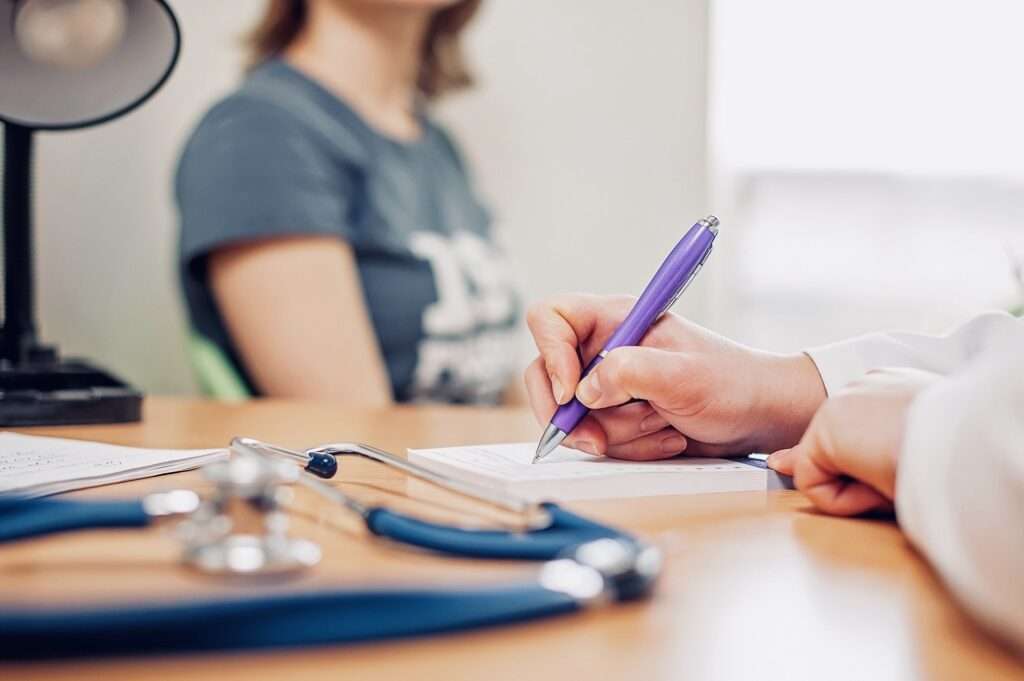 the patient sits with the doctor at the consultation and the doctor writes a prescription